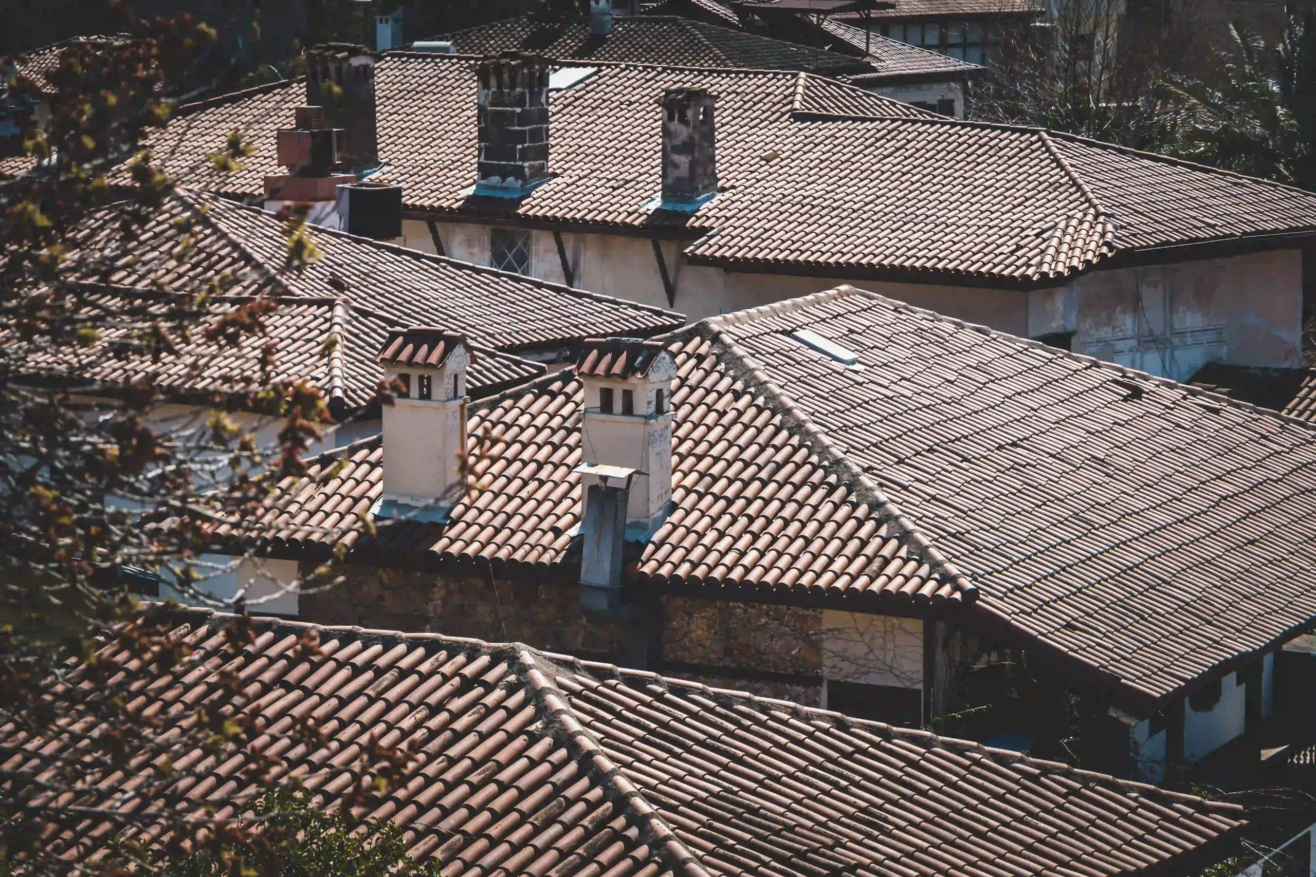 Older Surrey rooftops with traditional tiled roofs and chimneys, the type of property that may contain asbestos cement materials